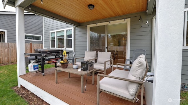 wooden deck with an outdoor hangout area and area for grilling