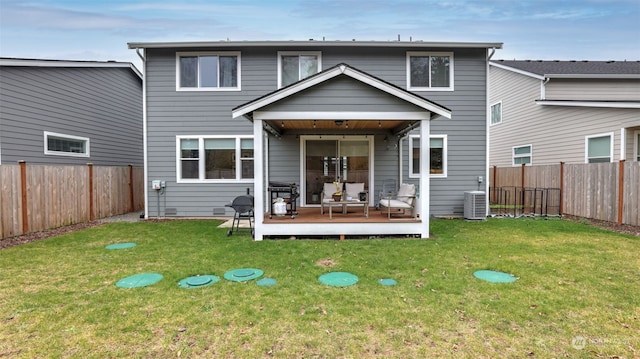 back of house with central AC unit, a deck, and a lawn