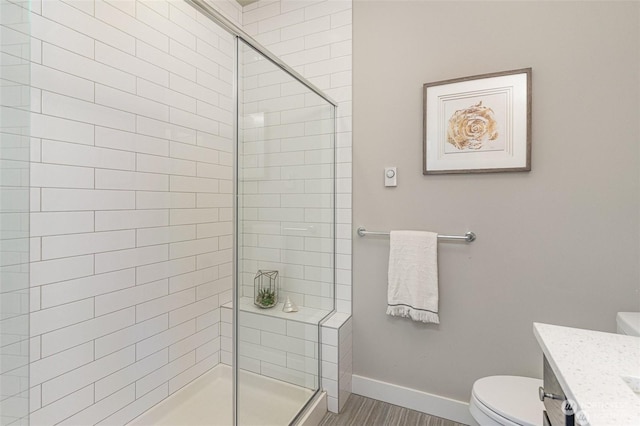 bathroom with toilet, hardwood / wood-style flooring, walk in shower, and vanity