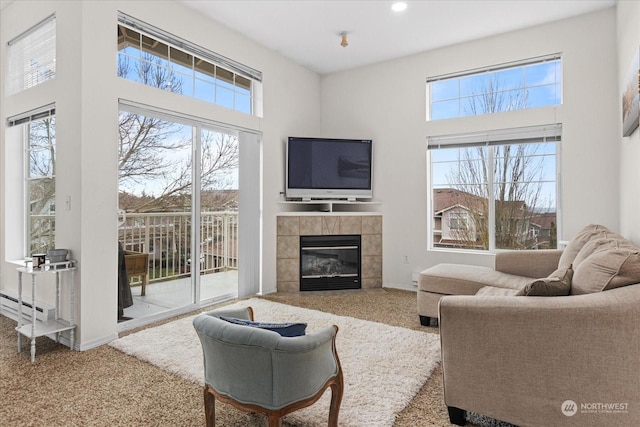 carpeted living room with a tile fireplace