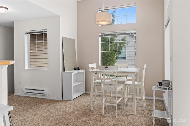 carpeted dining area featuring baseboard heating