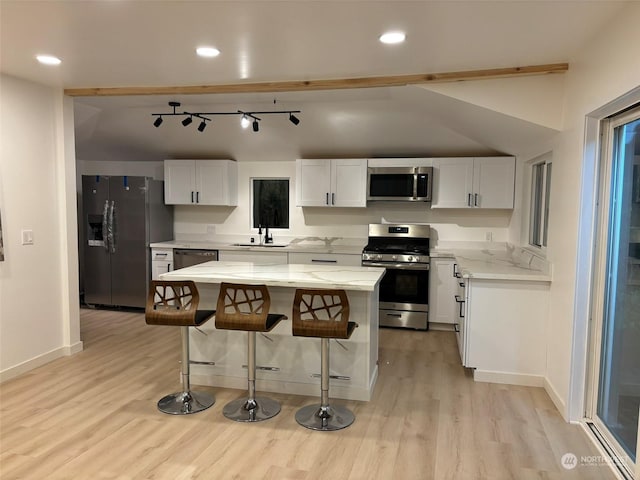 kitchen with light stone countertops, appliances with stainless steel finishes, sink, and white cabinetry