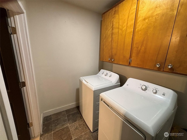 laundry room featuring washer and clothes dryer and cabinets