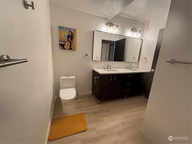 bathroom with wood-type flooring, toilet, and vanity