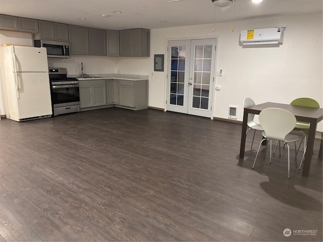 kitchen with appliances with stainless steel finishes, gray cabinetry, french doors, and an AC wall unit