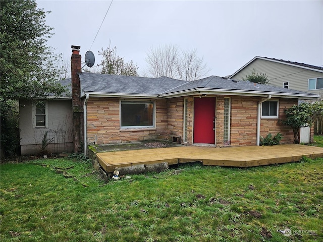 rear view of property with a yard and a wooden deck