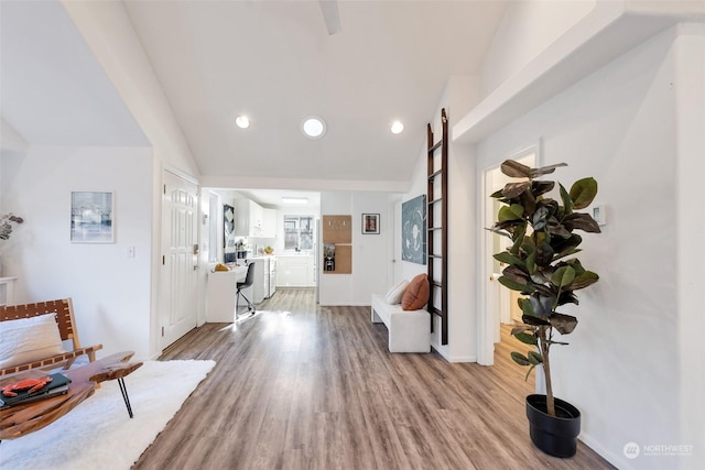 foyer entrance with light hardwood / wood-style flooring and lofted ceiling