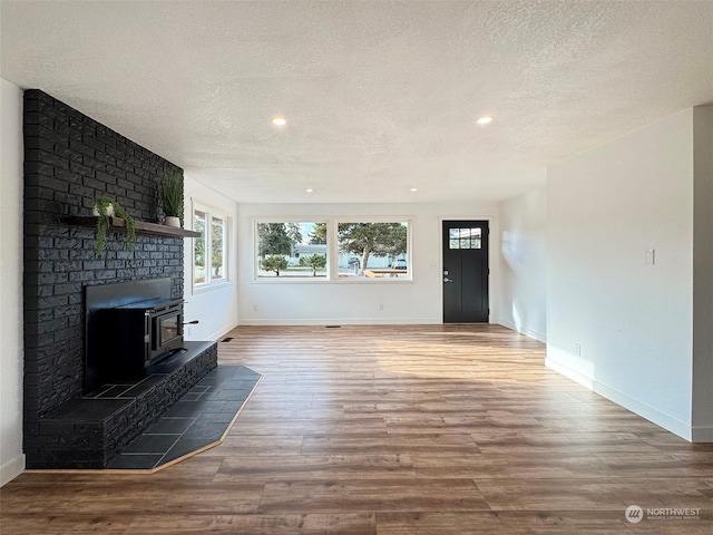 unfurnished living room featuring a textured ceiling and hardwood / wood-style floors