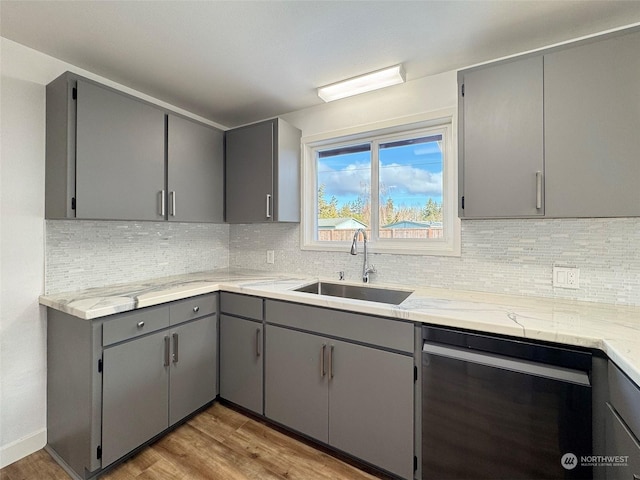 kitchen with gray cabinets, dishwasher, light hardwood / wood-style flooring, and sink