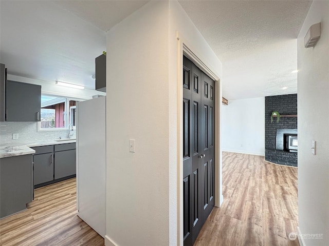 hall with sink and light hardwood / wood-style flooring