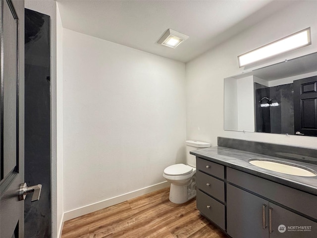 bathroom featuring toilet, vanity, and hardwood / wood-style floors