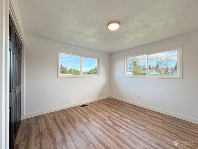 unfurnished bedroom featuring light hardwood / wood-style floors and a textured ceiling