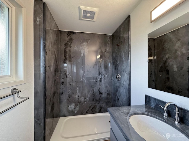 bathroom with vanity, bathing tub / shower combination, and a textured ceiling