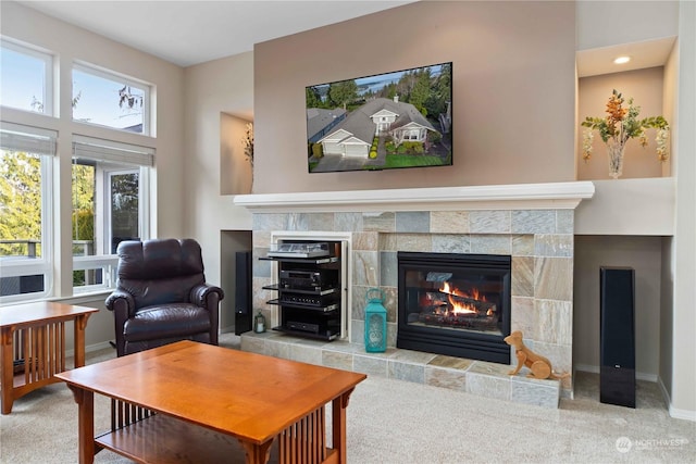 living room featuring a tiled fireplace and carpet