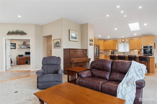 tiled living room featuring sink and a skylight