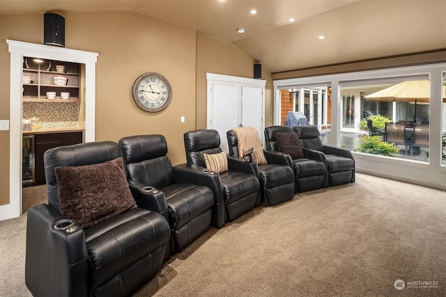 home theater room featuring vaulted ceiling and carpet