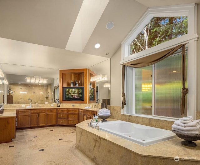 bathroom featuring a relaxing tiled tub, vanity, and high vaulted ceiling