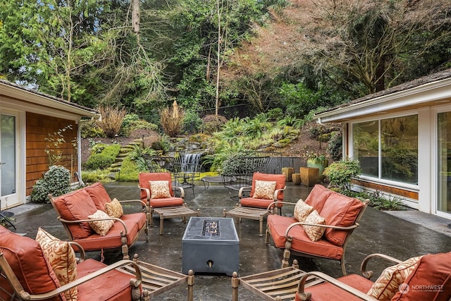 view of patio with an outdoor living space with a fire pit