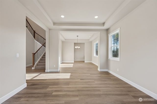 foyer featuring a raised ceiling, a chandelier, and hardwood / wood-style floors