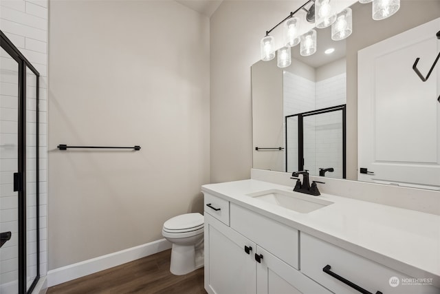 bathroom featuring a shower with shower door, hardwood / wood-style floors, toilet, and vanity