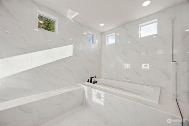 bathroom featuring tiled tub