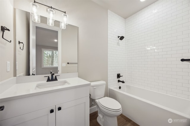 full bathroom featuring toilet, tiled shower / bath combo, hardwood / wood-style floors, and vanity