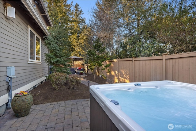 view of patio with a hot tub and a fenced backyard