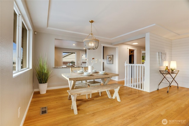 dining room with visible vents, baseboards, light wood-style floors, and a chandelier