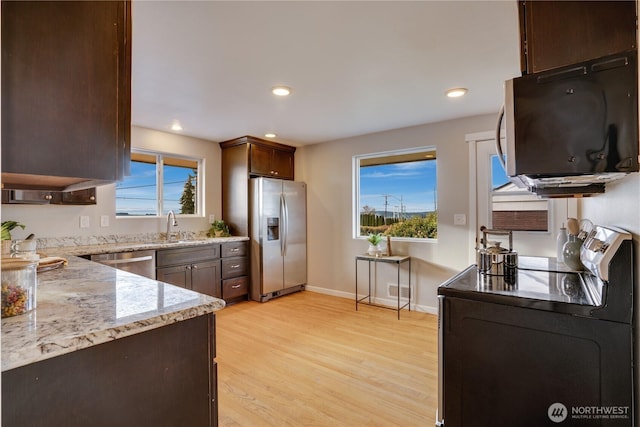 kitchen featuring a sink, stainless steel appliances, light wood-type flooring, and a healthy amount of sunlight