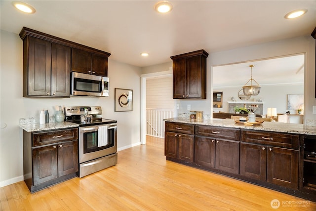 kitchen featuring light wood-type flooring, stainless steel appliances, light stone counters, and dark brown cabinets