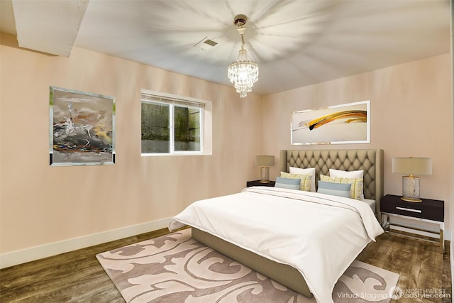 bedroom featuring visible vents, baseboards, a notable chandelier, and wood finished floors