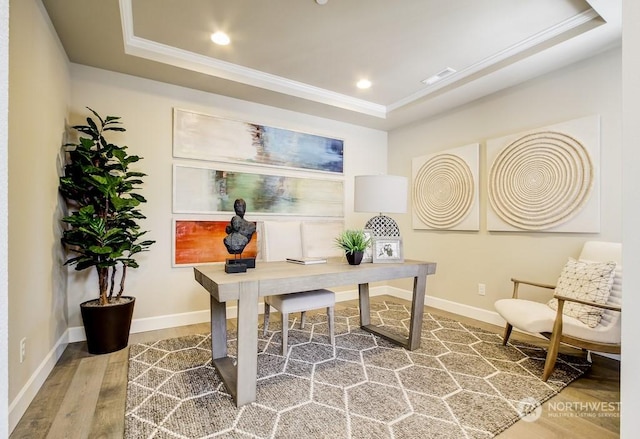 office area with crown molding, a tray ceiling, and hardwood / wood-style flooring