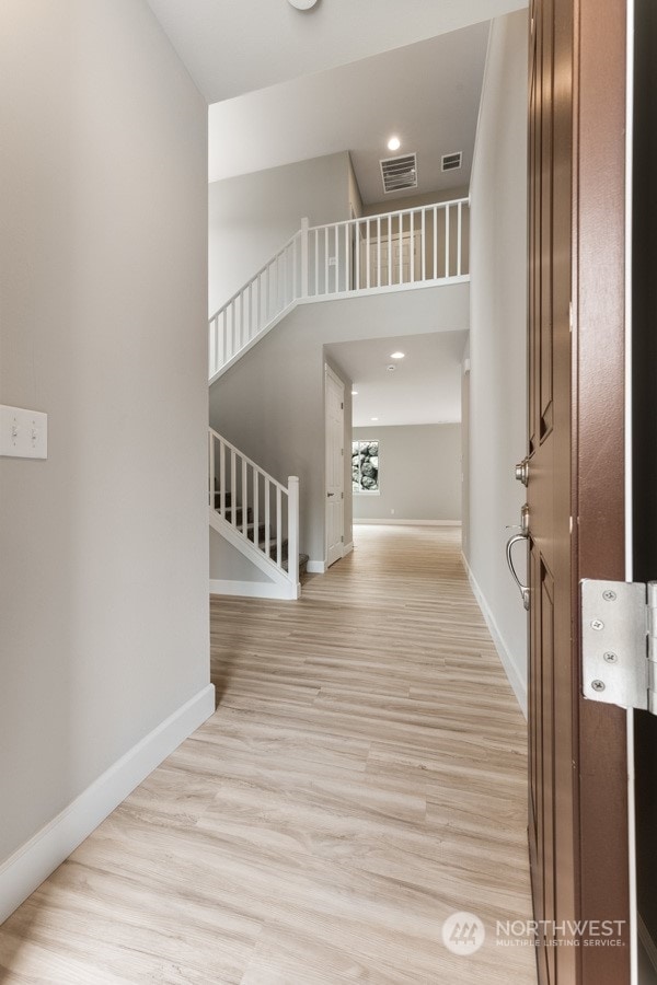 interior space with a high ceiling and light hardwood / wood-style flooring