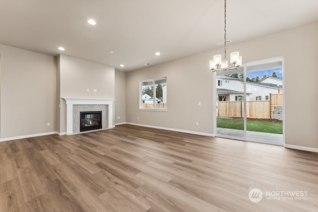 unfurnished living room with hardwood / wood-style flooring and a chandelier