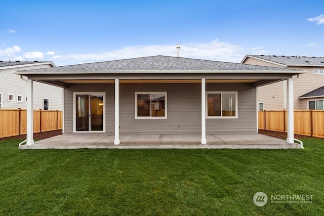 rear view of property featuring a lawn and a patio area