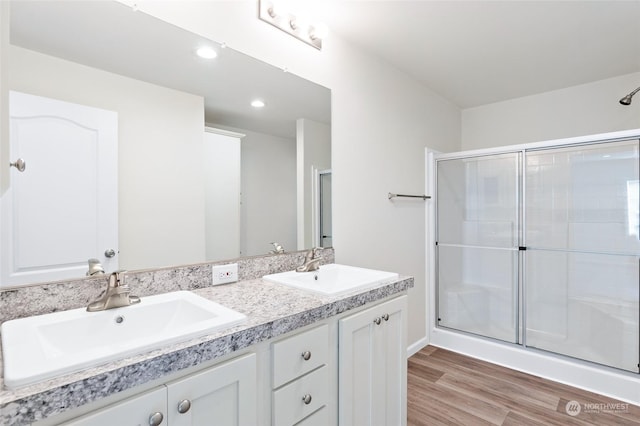 bathroom featuring wood-type flooring, vanity, and walk in shower