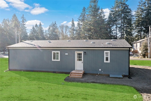 rear view of property featuring a lawn