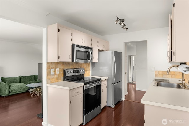 750 Crockett St Unit 403, Seattle, WA 98109 - kitchen with appliances with stainless steel finishes, dark wood-style flooring, tasteful backsplash, light countertops, and white cabinets