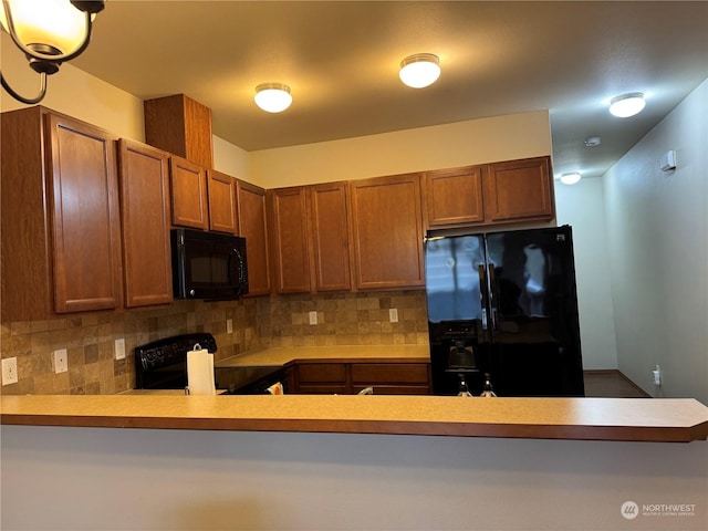 kitchen with decorative backsplash, black appliances, and kitchen peninsula