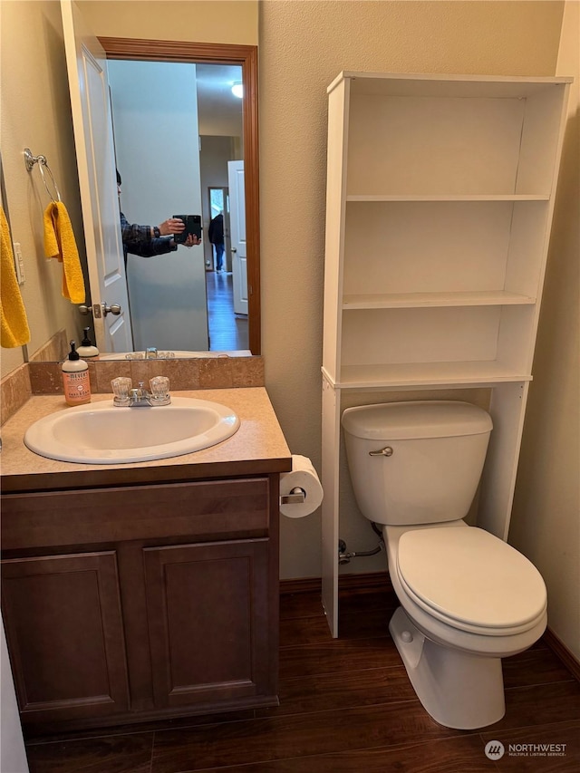 bathroom featuring hardwood / wood-style flooring, toilet, and vanity