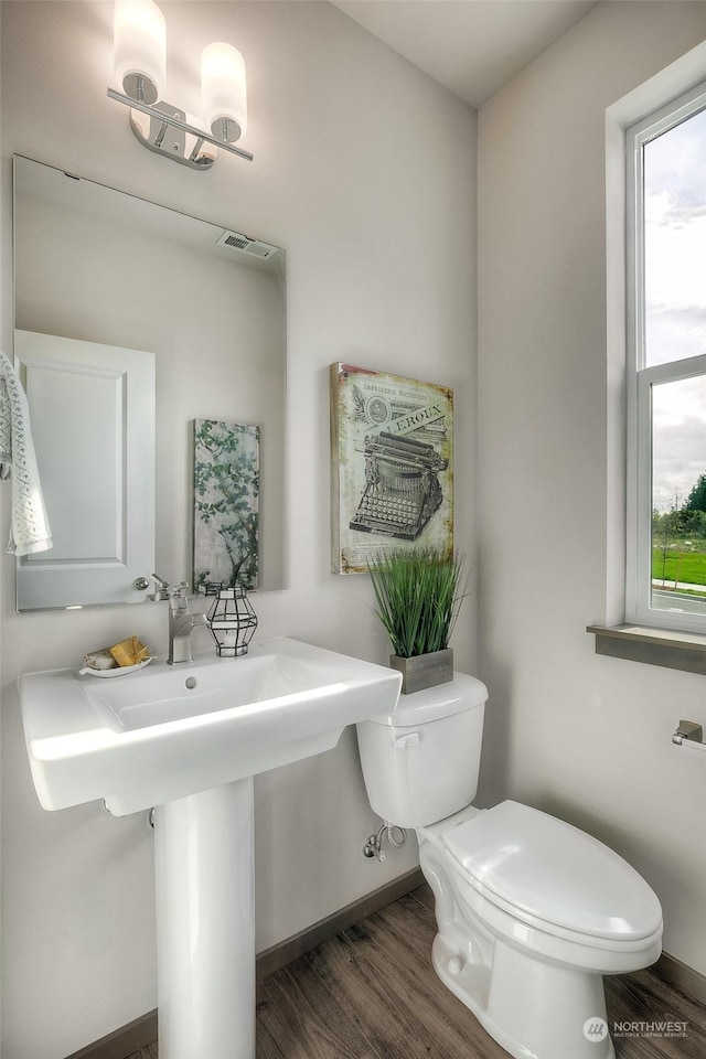 bathroom with toilet and hardwood / wood-style flooring