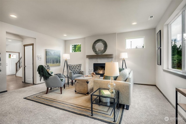 living room with carpet and a tile fireplace