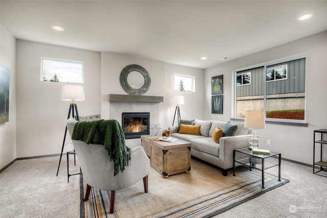 carpeted living room featuring a tiled fireplace