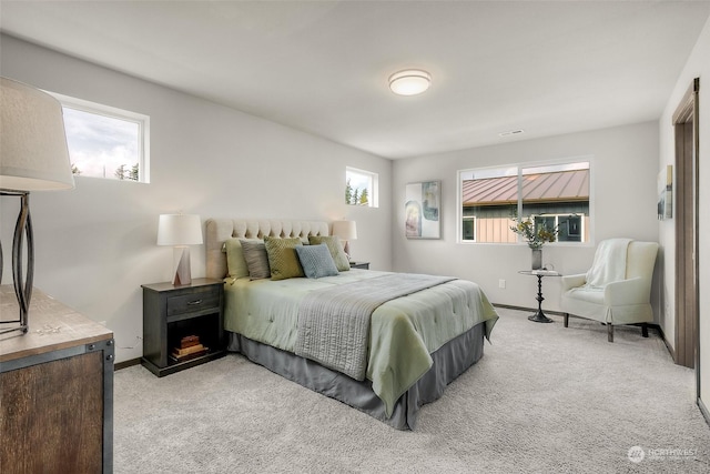 bedroom with light carpet and multiple windows