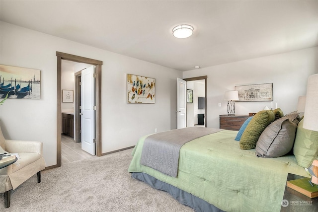 bedroom featuring light carpet and ensuite bath