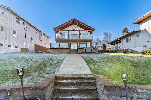 rear view of property featuring a lawn