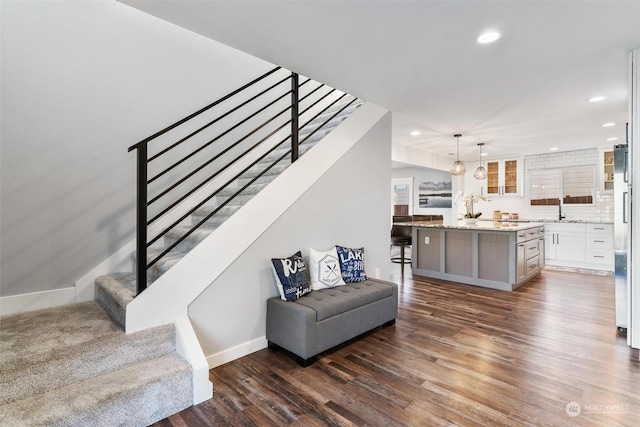 staircase featuring hardwood / wood-style flooring and sink