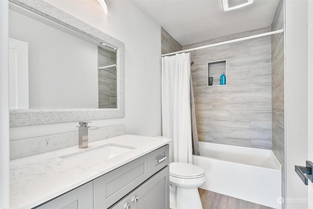 full bathroom featuring vanity, wood-type flooring, toilet, and shower / tub combo with curtain