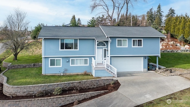 bi-level home featuring a garage and a front lawn