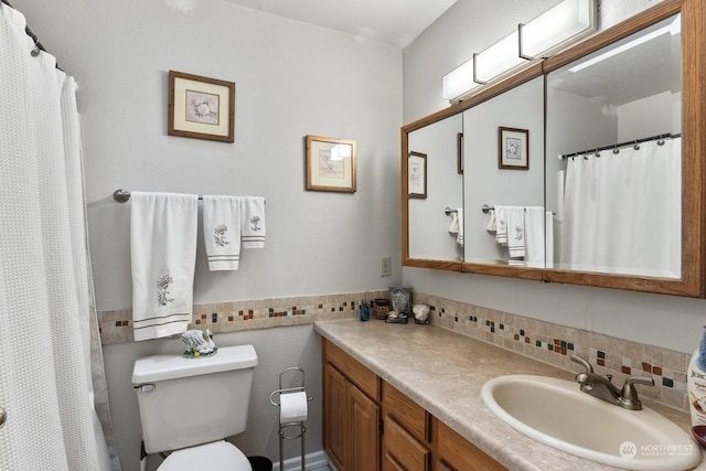 bathroom with vanity, curtained shower, decorative backsplash, and toilet